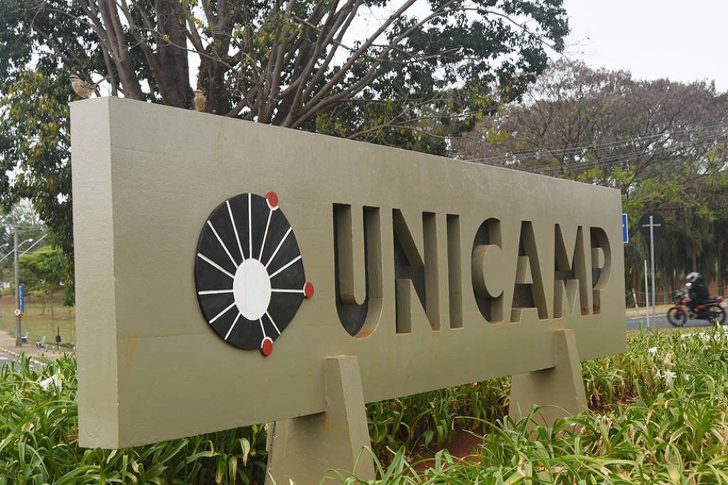A imagem mostra uma placa de sinalização da Universidade Estadual de Campinas (UNICAMP). A placa é de cor verde e apresenta o nome