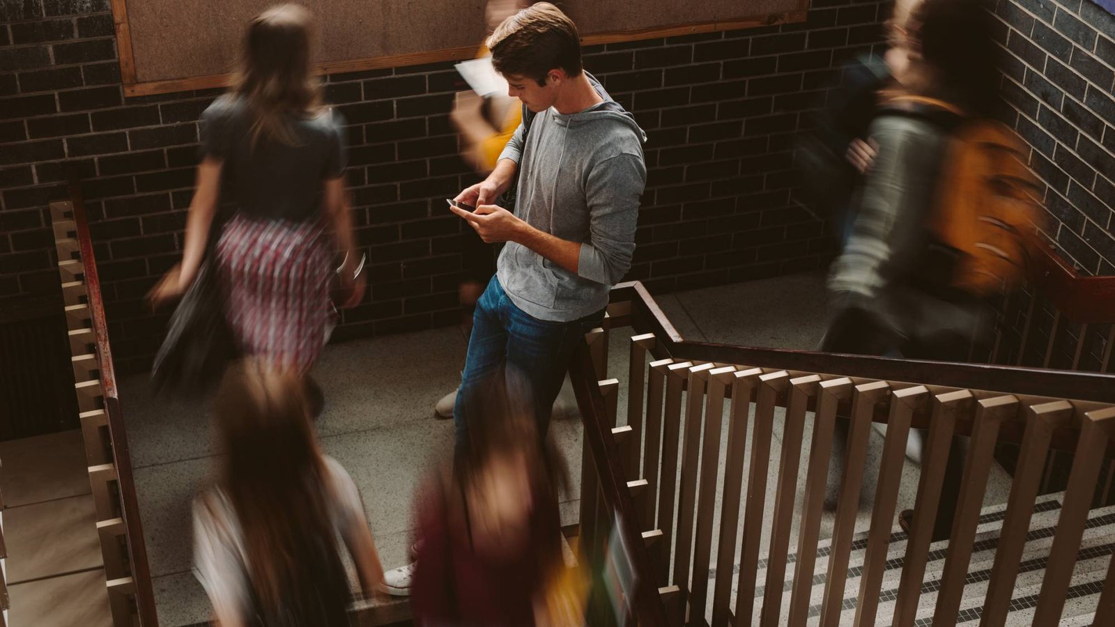 Young man on phone while crowd passes by
