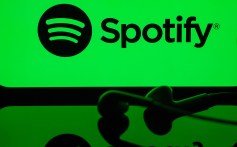 Nesta ilustração fotográfica, uma tela de telefone celular exibindo o logotipo do Spotify com um fone de ouvido na frente dele, em Ancara, Turkiye, em 01 de maio de 2024.