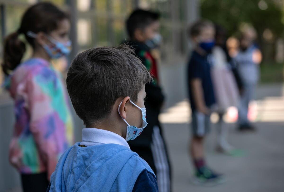 As crianças de crianças mascaradas esperam para tirar seus retratos para o dia de foto em setembro de 2020 na Rogers International School, em Stamford, Conn.