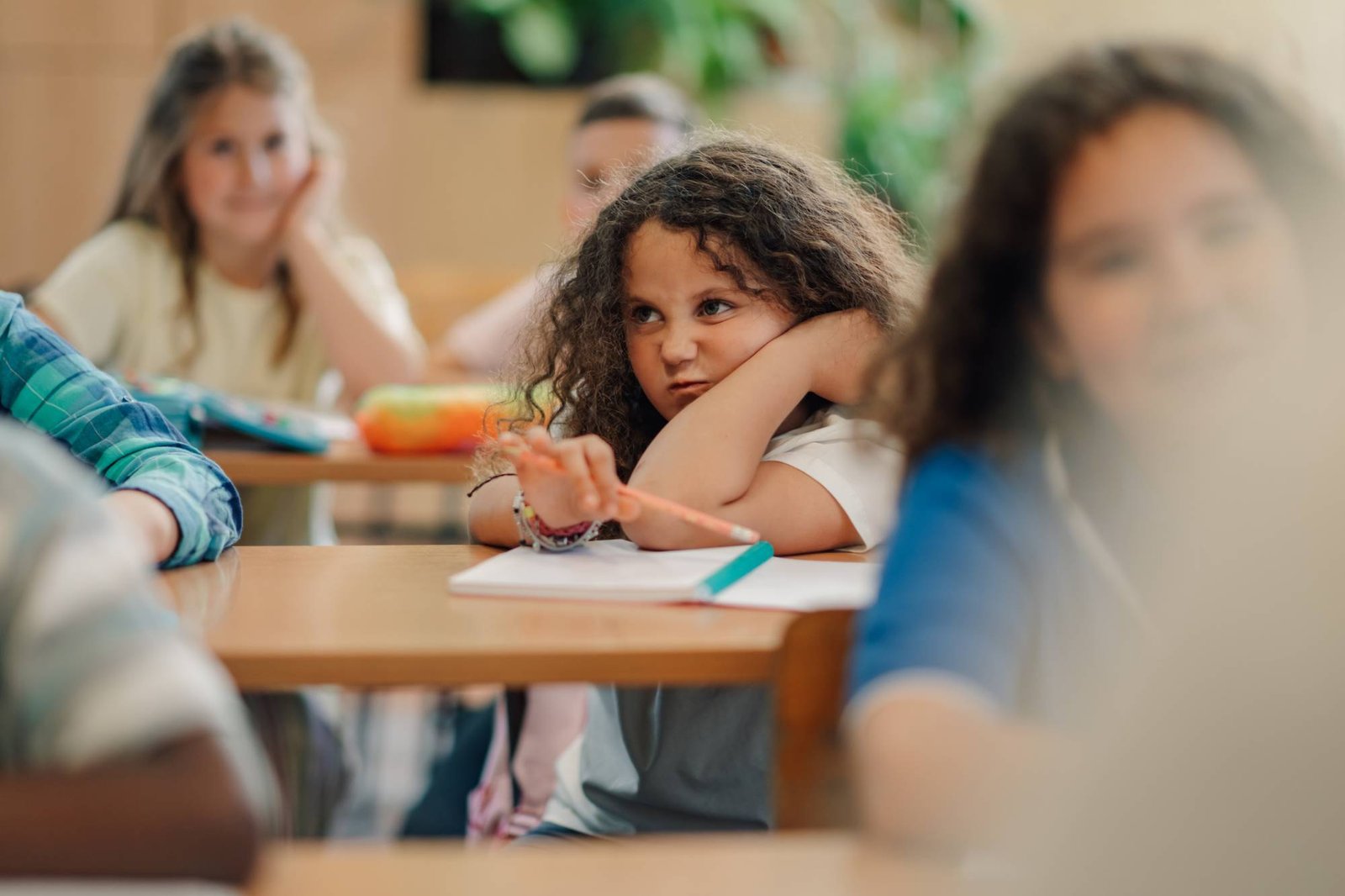 Bored elementary school student looking away during class