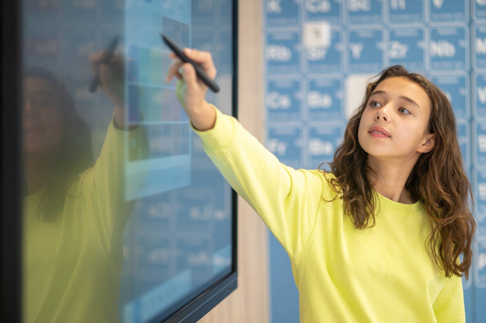 Girl standing near blackboard solving task