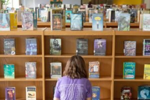 Student in front of rows of books