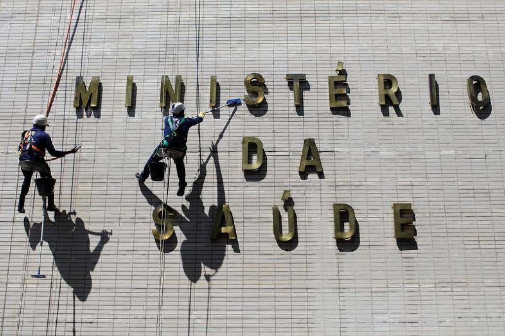 Funcionários limpam fachada do prédio do Ministério da Saúde, em Brasília