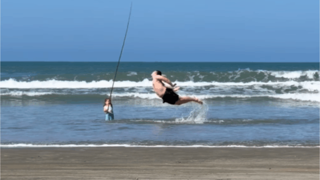Pai finge ser peixe fisgado na praia para realizar desejo da filha e vídeo viraliza: “Dando a vida na atuação”