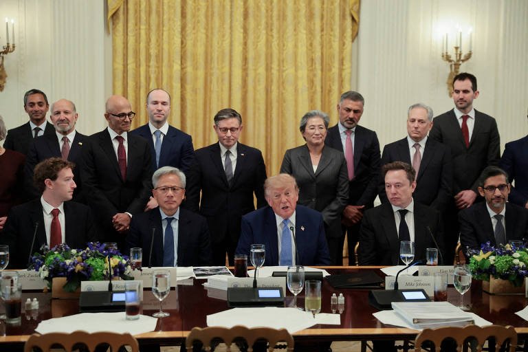 Donald Trump sentado ao centro de uma mesa de reunião na Casa Branca, cercado por executivos e autoridades, incluindo Elon Musk e Sundar Pichai, com cortinas douradas ao fundo.