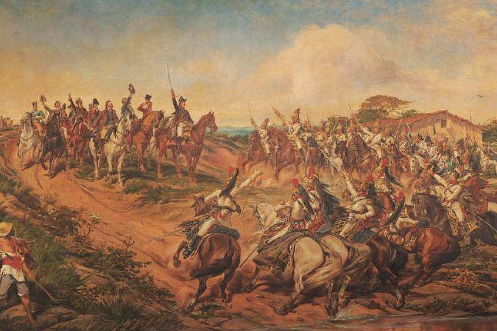 Cena de batalha com dezenas de cavaleiros armados em confronto em terreno aberto. Soldados a pé e a cavalo estão engajados em combate próximo a uma construção rústica, sob céu parcialmente nublado.